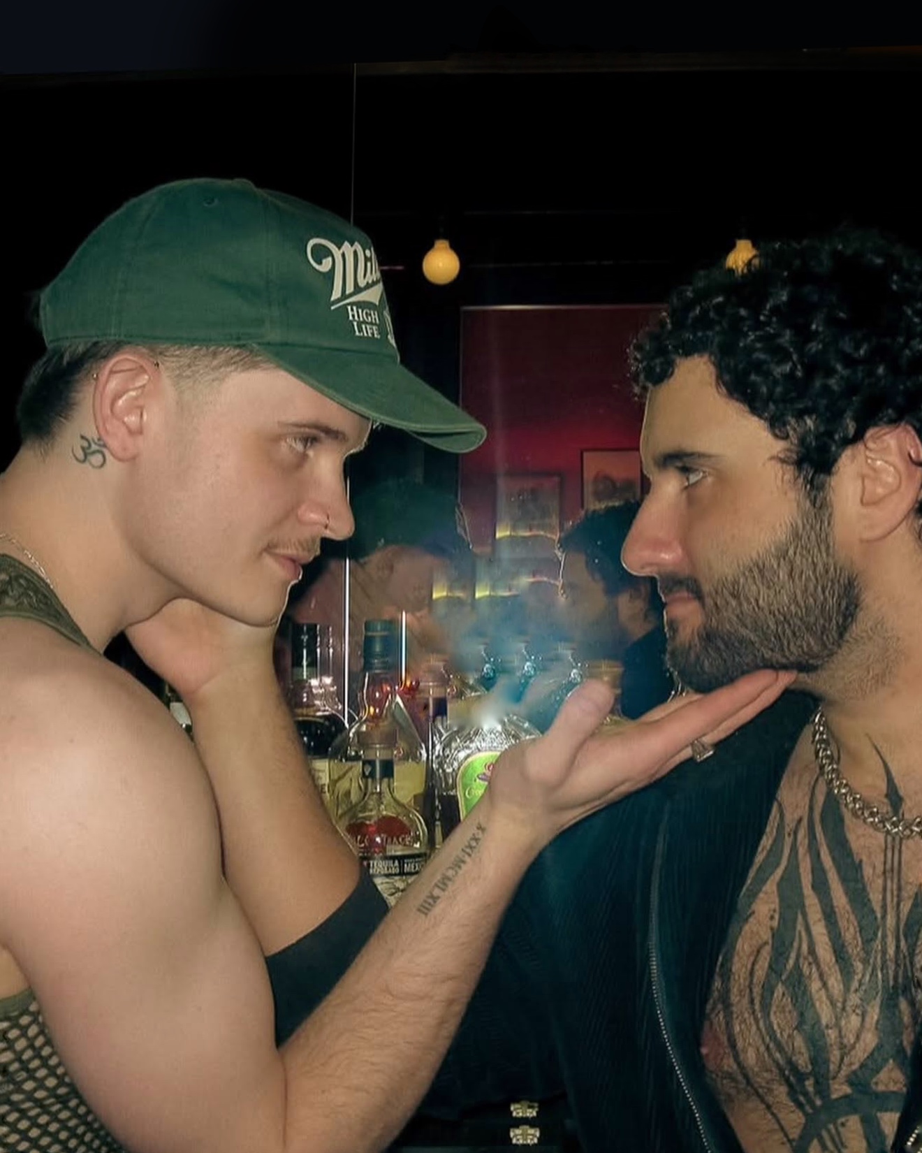 Two men leaning close together over the bar at El Trombone